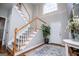 Bright entryway boasts a staircase with wood railings, a large arched window and neutral decor at 106 Victoria Way, Carrollton, GA 30116
