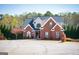 Charming two-story brick home features a dark roof, inviting front porch and well-manicured lawn and landscaping at 106 Victoria Way, Carrollton, GA 30116