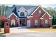 Charming two-story brick home featuring a dark roof, inviting front porch and well-manicured lawn and landscaping at 106 Victoria Way, Carrollton, GA 30116