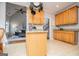 Kitchen with wooden cabinets, tile floors, granite countertops and a view into the living room at 106 Victoria Way, Carrollton, GA 30116