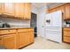 Well-lit kitchen with wood cabinets, granite countertops, and stainless steel refrigerator at 106 Victoria Way, Carrollton, GA 30116