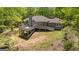 Aerial view of home showcasing back deck, wooded lot, and gray exterior paint at 679 Bo Bo Banks Rd, Grantville, GA 30220