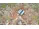 Detailed aerial view of the property showcasing a shed in the forest setting and solar panels on the roof at 679 Bo Bo Banks Rd, Grantville, GA 30220