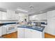 Spacious kitchen featuring a blue countertop island, white cabinets, and stainless steel appliances at 679 Bo Bo Banks Rd, Grantville, GA 30220