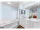Bright main bathroom features white cabinets, double sinks, modern fixtures, with a separate tub at 679 Bo Bo Banks Rd, Grantville, GA 30220