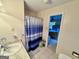 Well-lit bathroom featuring a single sink, shower with blue curtain, and tile flooring at 170 White Rd, Fayetteville, GA 30214