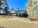Well-maintained brick home with green shutters and a spacious lawn, blending classic charm with natural surroundings at 170 White Rd, Fayetteville, GA 30214