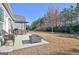 Landscaped backyard with a fire pit, patio umbrella, furniture, lawn and treeline, perfect for outdoor entertaining at 305 Roundwood Way, Peachtree City, GA 30269