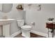 Well-lit half bathroom featuring a pedestal sink, decor, and wood-look flooring at 305 Roundwood Way, Peachtree City, GA 30269