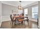 Bright dining room with stylish light fixture and wainscoting at 305 Roundwood Way, Peachtree City, GA 30269