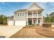 Charming two-story home featuring a double front porch and an attached three-car garage at 305 Roundwood Way, Peachtree City, GA 30269