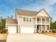 Beautiful two-story home featuring a welcoming porch and an attached three-car garage at 305 Roundwood Way, Peachtree City, GA 30269