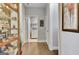 Hallway view features hardwood floors, display cabinet, art and view into laundry and other rooms at 305 Roundwood Way, Peachtree City, GA 30269