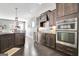 Modern kitchen with dark wood cabinets and island with granite countertops and stainless appliances at 305 Roundwood Way, Peachtree City, GA 30269