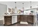 Modern kitchen island with stainless steel dishwasher and dark wood cabinets and breakfast bar at 305 Roundwood Way, Peachtree City, GA 30269