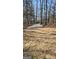 Wide gravel driveway leading into a wooded property showcasing a natural entrance and setting at 3189 Fern Ridge Ne Dr, Conyers, GA 30013