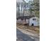 Exterior view of home highlighting the elevated wooden deck and outdoor utilities, set against a wooded backdrop at 3189 Fern Ridge Ne Dr, Conyers, GA 30013