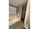 Bathroom with a soaking tub, a large window, and gray granite tile flooring at 133 Ventura Trl, Stockbridge, GA 30281