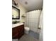 Well-maintained bathroom with a decorative mirror, a shower curtain, and granite tile flooring at 133 Ventura Trl, Stockbridge, GA 30281