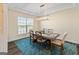 Dining room with tray ceiling, modern chandelier, large window, and vibrant blue rug at 814 Parker Pass, Peachtree City, GA 30269