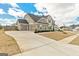 A tan two-story home with a three-car garage and a long concrete driveway at 814 Parker Pass, Peachtree City, GA 30269