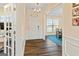 Entryway featuring hardwood floors, white wainscoting, and view of the dining room at 814 Parker Pass, Peachtree City, GA 30269