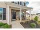 Inviting front porch with stone accents, black door with wreath, seating, and manicured landscaping at 814 Parker Pass, Peachtree City, GA 30269