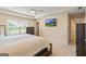 This primary bedroom has a large window, ceiling fan, mounted TV, and ensuite bathroom access at 814 Parker Pass, Peachtree City, GA 30269