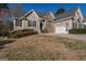 Inviting home featuring stone accents, a two-car garage, and well-maintained landscaping in a suburban setting at 1491 Hada Ln, Lawrenceville, GA 30044