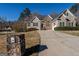 Attractive home with stone and siding exterior, a well-kept lawn, and a long driveway leading to a two-car garage at 1491 Hada Ln, Lawrenceville, GA 30044