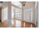 Bright foyer features hardwood floors, transom window over door, elegant chandelier and decorative columns and moldings at 1491 Hada Ln, Lawrenceville, GA 30044
