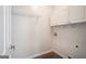 Laundry room featuring white cabinets, hook and wood floors at 1491 Hada Ln, Lawrenceville, GA 30044