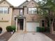 Inviting brick townhome with well-manicured landscaping, a one-car garage, and a charming covered entrance at 2742 Keystone Gates Ct, Lithonia, GA 30058