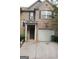Charming two-story brick townhome featuring a one-car garage and a welcoming covered front entry at 2742 Keystone Gates Ct, Lithonia, GA 30058