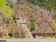 An aerial shot of a home with a metal roof surrounded by a lush forest at 327 Old Muse Rd, Carrollton, GA 30116