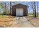 A large outbuilding featuring a metal roll-up door and private driveway offers extra space at 327 Old Muse Rd, Carrollton, GA 30116