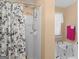 Bathroom with a shower/tub combo, floral shower curtain, safety seat and decorative window at 1100 Parkside Ln, Mcdonough, GA 30253