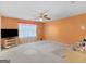 Spacious bedroom with a ceiling fan and a large window with a peach-colored wall at 1100 Parkside Ln, Mcdonough, GA 30253