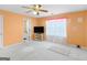 Bright bedroom with a ceiling fan, peach walls, and a view of an adjacent bathroom at 1100 Parkside Ln, Mcdonough, GA 30253