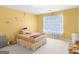 Bright bedroom featuring yellow walls, floral accents, and a cozy bed with light pouring through the window at 1100 Parkside Ln, Mcdonough, GA 30253