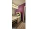 Bright bathroom features a purple accent wall, sleek vanity, and well-lit mirror at 255 Squire Ln, Fayetteville, GA 30214