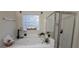 Bathroom featuring a soaking tub, glass-enclosed shower, and a large window for natural light and ventilation at 255 Squire Ln, Fayetteville, GA 30214