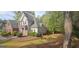 Home exterior with gray siding, brick, and a spacious lawn in a wooded neighborhood at 255 Squire Ln, Fayetteville, GA 30214