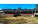 Rear exterior view of a brick home with well-maintained lawn and some trees at 6268 Mount Zion Blvd, Morrow, GA 30260