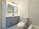 Modern bathroom features a gray vanity, sleek mirror, and tiled walls near a toilet at 6268 Mount Zion Blvd, Morrow, GA 30260