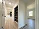 Inviting hallway with light wood floors and convenient shelving near an open-concept living area at 6268 Mount Zion Blvd, Morrow, GA 30260
