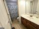 Well-maintained bathroom features a vanity, toilet, and shower with blue patterned curtain at 1441 Henderson Ridge Ln, Loganville, GA 30052