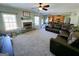 Open-concept living room with a fireplace, large windows, and a leather sectional at 1441 Henderson Ridge Ln, Loganville, GA 30052
