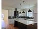 Well-lit kitchen with black backsplash, stainless hood, and large island with white countertop at 721 Cascade Sw Ave, Atlanta, GA 30310