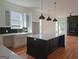 Modern kitchen featuring a large island, farmhouse sink, and stylish black backsplash at 721 Cascade Sw Ave, Atlanta, GA 30310
